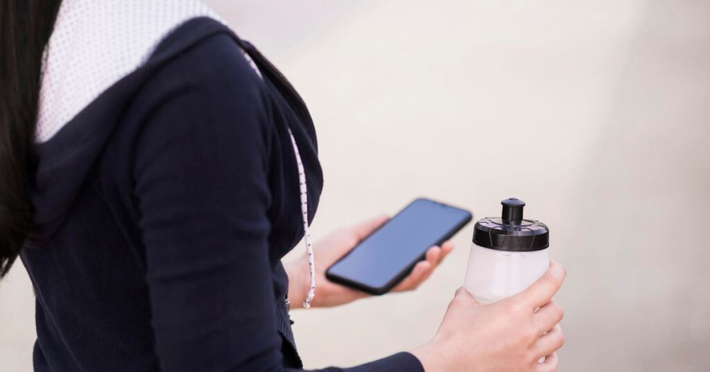 A Close-up of Women With Mobile And Water Bottle Concept of Is Carrier Hub a Spy App?
