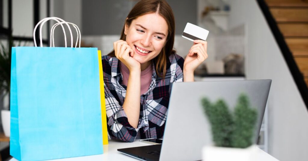 A smiling woman with a card and laptop concept of what is snap finance